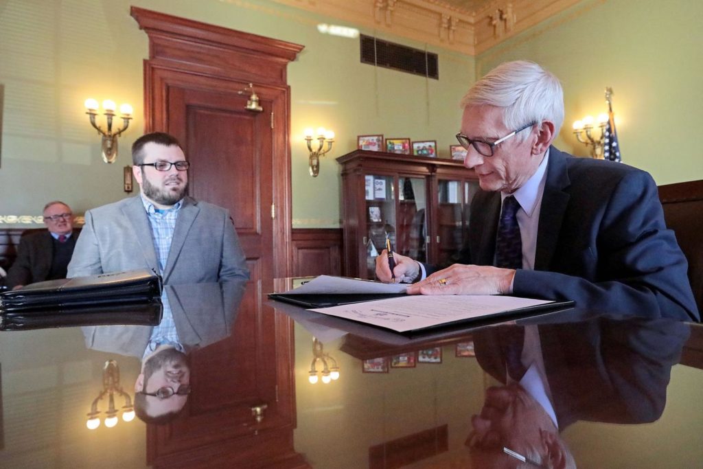 Gov. Tony Evers signs a non-violent offense pardon for Bradley Cummings